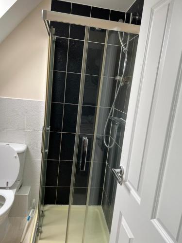 a shower with a glass door in a bathroom at Tuffley 4 bedroom house in Quedgeley