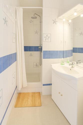 une salle de bain blanche avec un lavabo et une douche dans l'établissement Rêve Marin, vue imprenable sur l'océan, à Saint-Hilaire-de-Riez