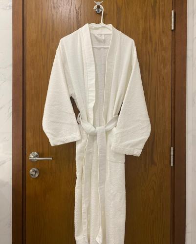 a robe is hanging on a door at Beachfront 2BHK apartment at Al Mouj in Seeb