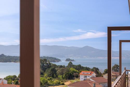 a view of the ocean from a house window at Apartamentos Rurales de Abelleira in Muros