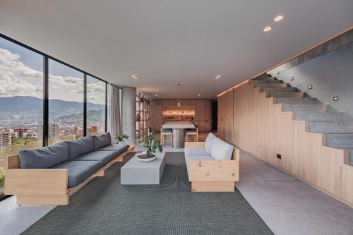 a living room with a couch and a staircase at The Somos Loho Hotel in Medellín