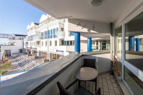 a balcony with two chairs and a view of a building at Kranichtanz an der Seebrücke in Zingst