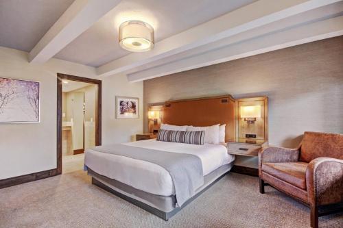 a hotel room with a large bed and a chair at Lodge at Vail, A RockResort in Vail