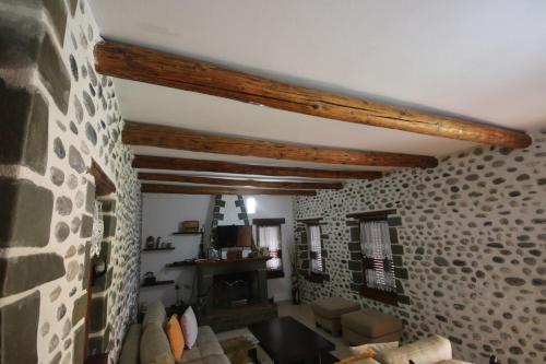 a living room with a stone wall and a fireplace at Guest House Mehmeti in Tolar