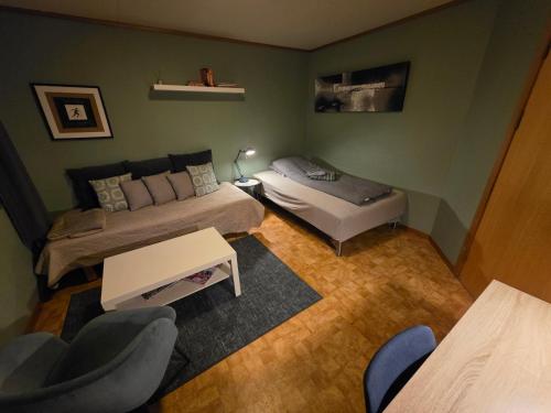 a bedroom with two beds and a table and chairs at Rom 4 i bufellesskap in Sogndal