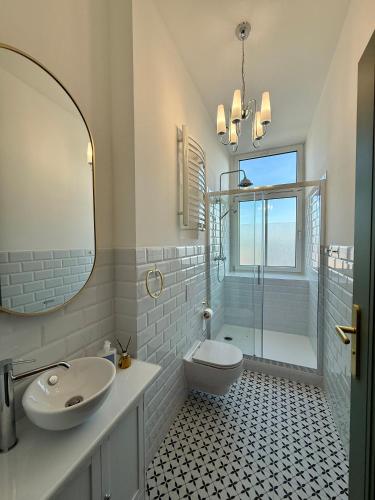 a bathroom with a sink and a toilet and a mirror at Vintage Rooms in Przemyśl