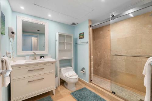 a bathroom with a toilet and a glass shower at Beachfront - Emerald View 2BR condo - P416 in Palm-Eagle Beach