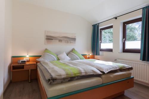 een slaapkamer met een bed en 2 ramen bij Haus Alexandra in Willingen