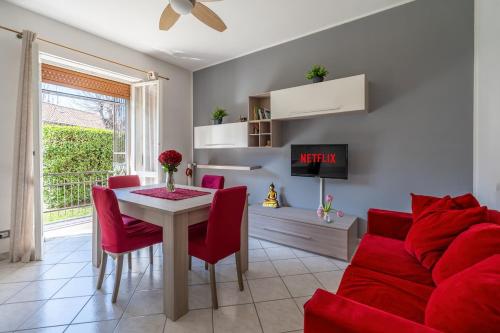 a living room with a red couch and a table at Humanitas Very bright with Balcony with SmartWorking in Rozzano