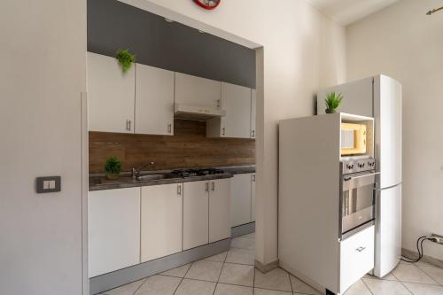 a kitchen with white cabinets and a refrigerator at Humanitas Very bright with Balcony with SmartWorking in Rozzano