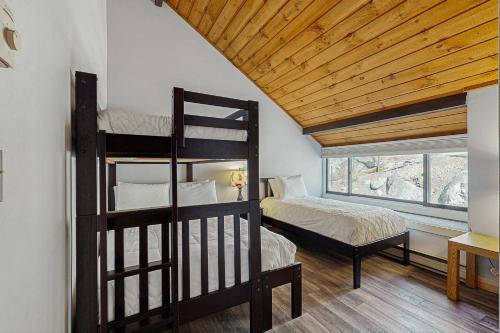 Un dormitorio con dos literas y una ventana. en Loon Mountain Nest, en Lincoln