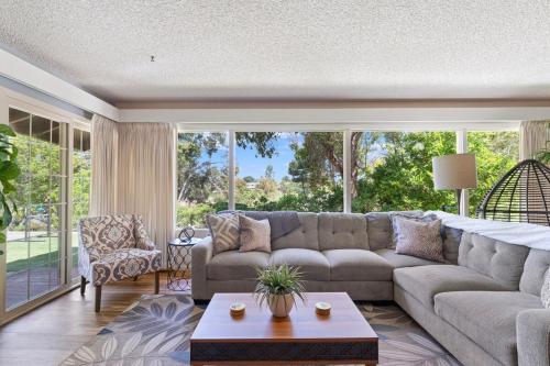 a living room with a couch and a large window at Home in San Diego! The Blue Leaf with 3bed 2bath, Golf, Large Yard! in Rancho Bernardo