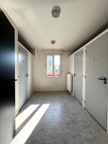 une chambre vide avec un couloir et une fenêtre dans l'établissement Chambre studio centre ville Dol de Bretagne, à Dol-de-Bretagne