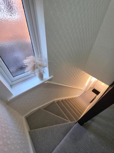 a room with a window with a feather at Stunning property with Summer house in Bescot