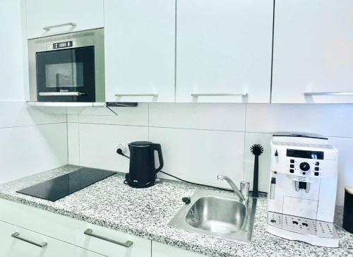 a kitchen with a sink and a coffee maker at Central city apartment in Zurich! in Zürich