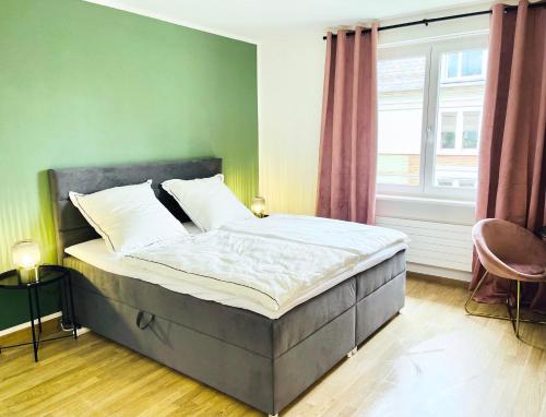 a bed in a bedroom with a green wall at Central city apartment in Zurich! in Zürich