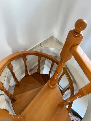 a wooden spiral staircase with a wooden rail at Daisy Maisonette in Póros Kefalonias
