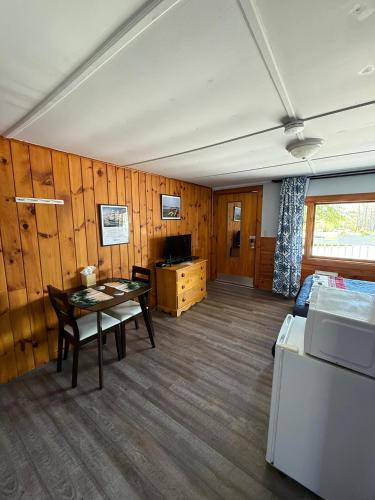 a room with a table and a bed and a desk at Yardarm Motel in Searsport