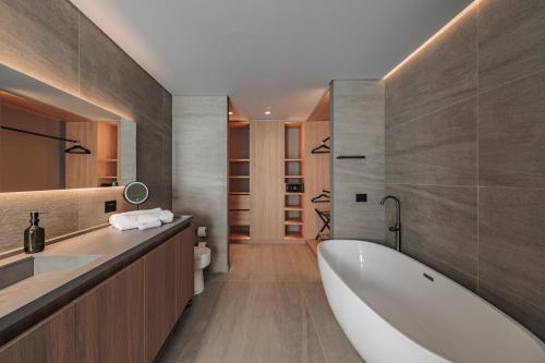 a bathroom with a tub and a toilet and a sink at The Somos Loho Hotel in Medellín