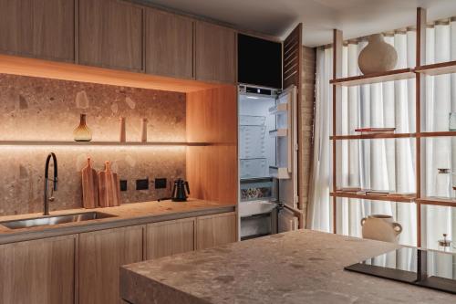 a kitchen with wooden cabinets and a counter top at The Somos Loho Hotel in Medellín