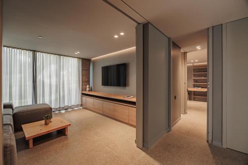 a living room with a tv and a couch and a table at The Somos Loho Hotel in Medellín