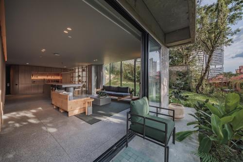 an open living room with glass walls and a couch at The Somos Loho Hotel in Medellín