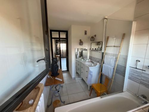 a bathroom with a tub and a sink at L'appartement du bonheur - Au Cœur des Volcans d'Auvergne sur la Route du Sud in Issoire
