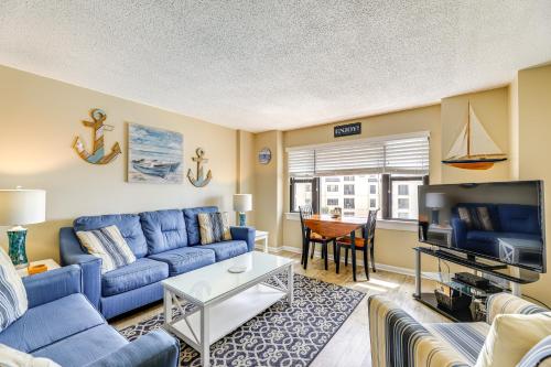a living room with a blue couch and a table at Walk to Indian Beach Condo with Ocean-View Balcony in Indian Beach