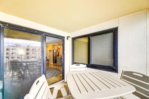 a balcony with a bench and a large window at Walk to Indian Beach Condo with Ocean-View Balcony in Indian Beach