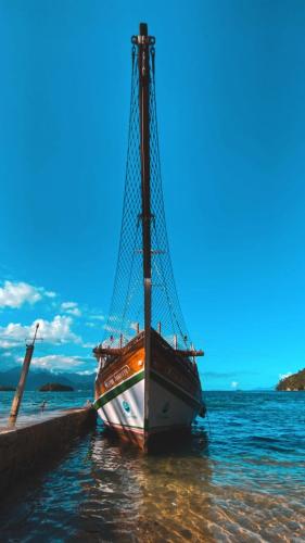 a boat sitting at a dock in the water at Hostel ABC in Angra dos Reis