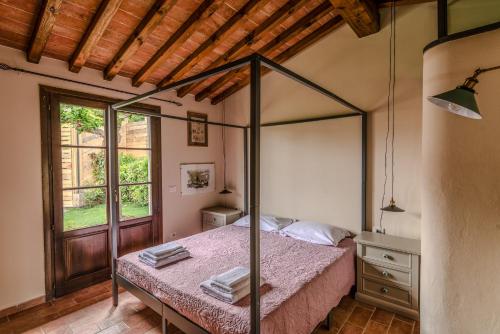 Un dormitorio con una cama con dosel en una habitación. en Amis Home, en Castelnuovo D'elsa