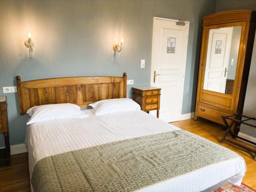 a bedroom with a large bed with white sheets at Logis Hôtel Beau Site in Argelès-Gazost