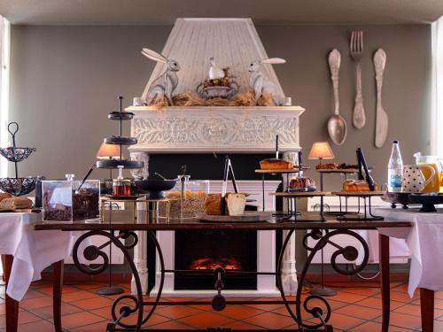 a table with food on it with a fireplace at Hôtel Restaurant Verger des Châteaux, Route des vins Haut-Koenigsbourg in Dieffenthal