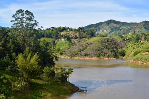 a river with a boat in the middle at Rooca Habitat Guatape in Guatapé