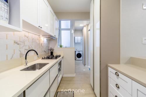 a kitchen with white cabinets and a sink at Lindos Apartamentos no Centro de Floripa - CPN in Florianópolis