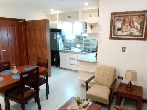 una cucina e una sala da pranzo con tavolo e sedie di Lujoso departamento cerca la Plaza Principal a La Playa Bejarano
