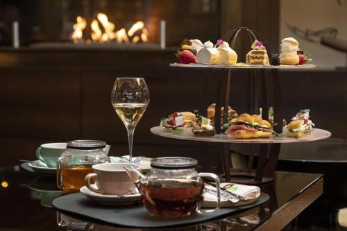a table with two plates of food and a glass of wine at Kempinski Hotel Corvinus Budapest in Budapest
