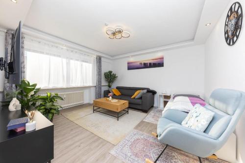 a living room with a blue chair and a couch at Ferienwohnung Sarah für 6 Gäste in Andernach