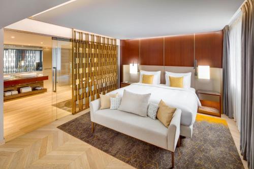 a bedroom with a large bed and a couch at Kempinski Hotel Corvinus Budapest in Budapest