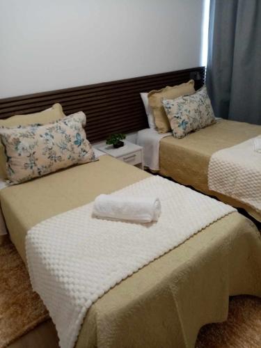 a room with two beds with towels on them at Vivenda Silva in Seixal