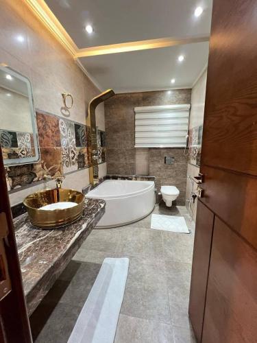 Un baño con bañera, lavabo e inodoro. en الازرق فارم, en Al Azraq ash Shamālī