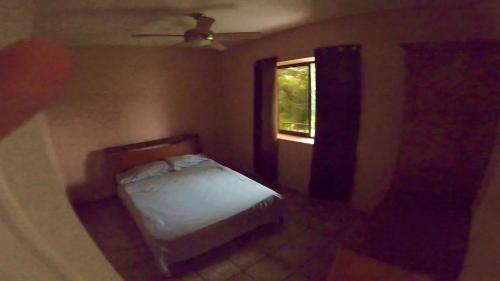 a small bedroom with a bed and a window at Casa Vista Pacifico in Esterillos