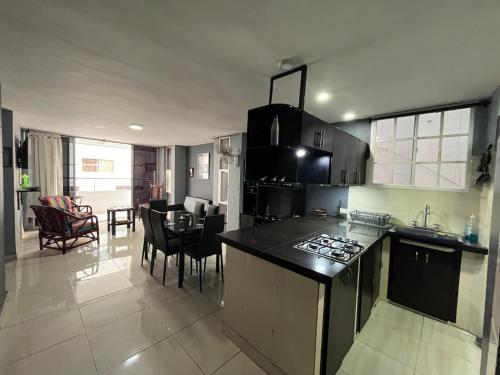 Una cocina y una sala de estar con mesa y sillas. en Hermosa Vista al Mar en Rodadero, en Gaira