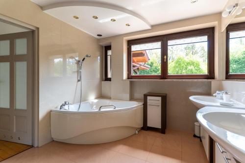 a bathroom with a large tub and two sinks at Willa Hamptons in Huta Podgórna