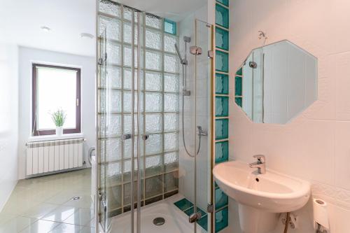 a white bathroom with a sink and a shower at Willa Hamptons in Huta Podgórna