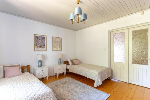 a white room with two beds and a window at Willa Hamptons in Huta Podgórna