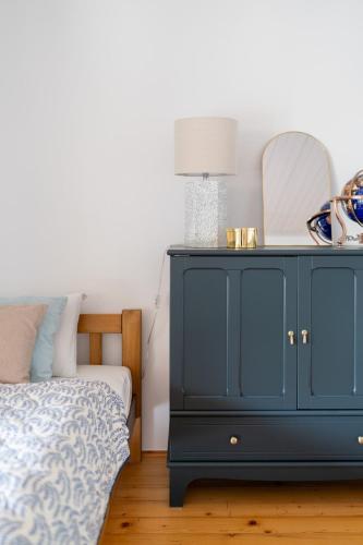a bedroom with a blue cabinet and a bed at Willa Hamptons in Huta Podgórna