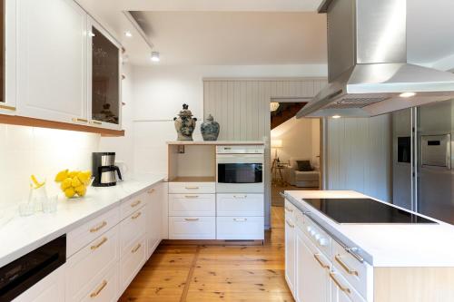 a kitchen with white cabinets and white counters at Willa Hamptons in Huta Podgórna