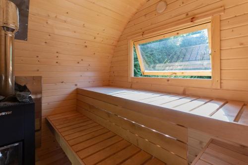a bench in a wooden sauna with a window at Willa Hamptons in Huta Podgórna