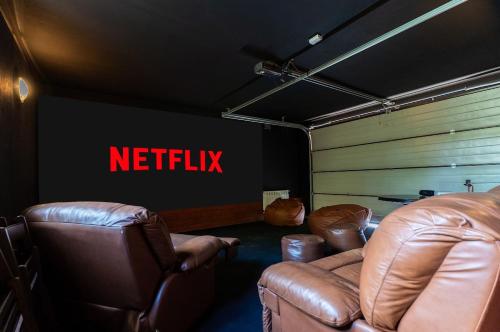 a waiting room with leather chairs and a netflix sign at Willa Hamptons in Huta Podgórna